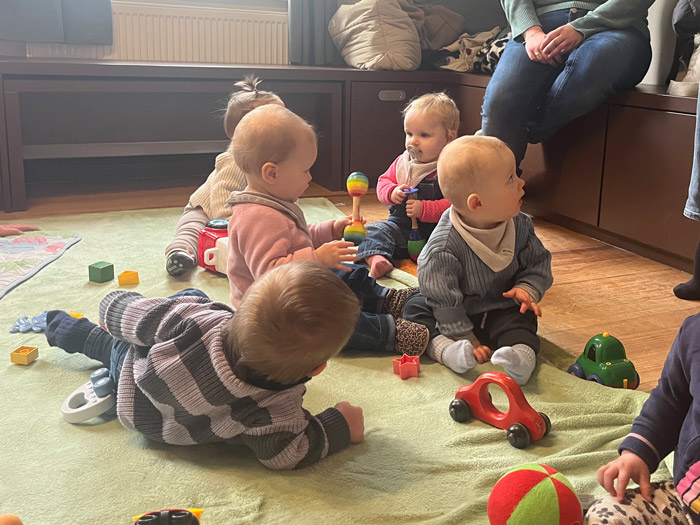 Eine Gruppe Babys sitzt auf dem Boden