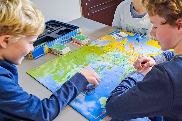 Drei Jungs spielen ein Brettspiel